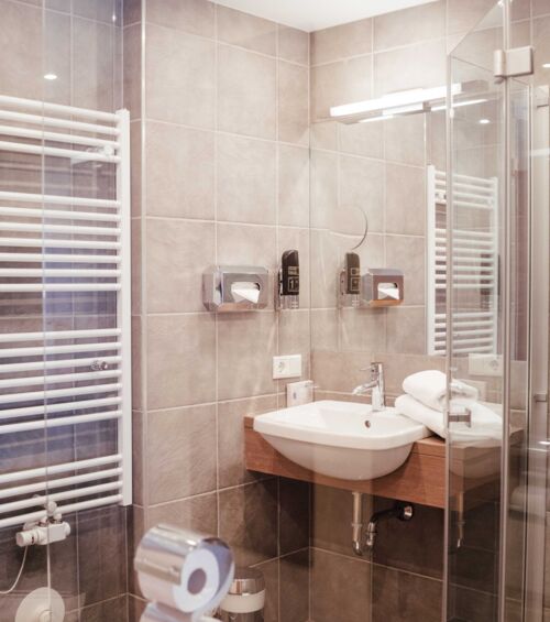 Modernes Badezimmer mir Glas Duschwand, Handtuchwärmer und Waschbecken