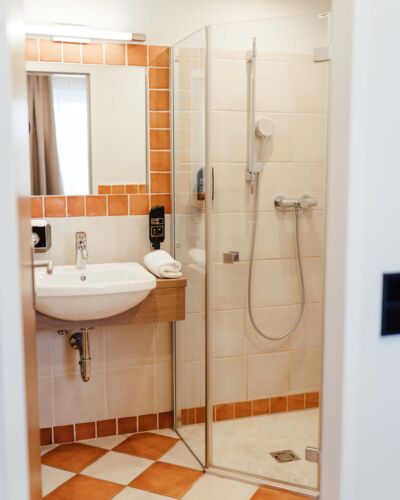 Badezimmer mit Glas Walk-In Dusche und Waschbecken