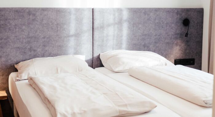 Das frisch bezogene Doppelbett im Doppelzimmer Gästhaus im 4-Sterne-Hotel Kirchbichl