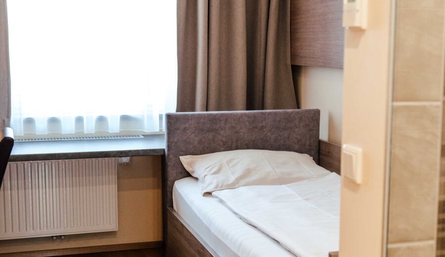 Einzelbett im Einzelzimmer mit großem Fenster im Hotel Kirchbichl