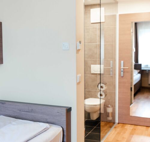 Blick vom Schlafzimmer ins Badezimmer des Einzelzimmers im Landgasthof Kirchbichl
