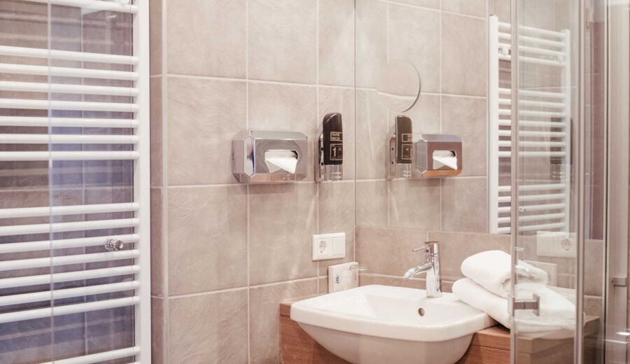Modernes Badezimmer mir Glas Duschwand, Handtuchwärmer und Waschbecken
