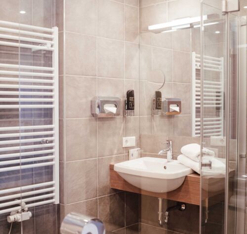 Modernes Badezimmer mir Glas Duschwand, Handtuchwärmer und Waschbecken