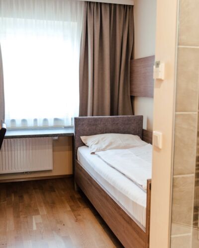 Einzelbett im Einzelzimmer mit großem Fenster im Hotel Kirchbichl