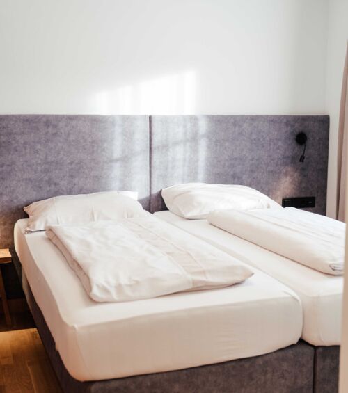 Das frisch bezogene Doppelbett im Doppelzimmer Gästhaus im 4-Sterne-Hotel Kirchbichl