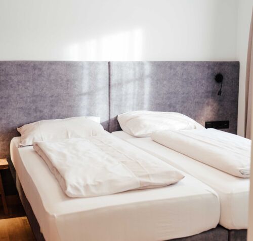 Das frisch bezogene Doppelbett im Doppelzimmer Gästhaus im 4-Sterne-Hotel Kirchbichl