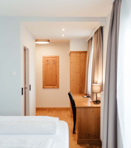 Schreibtisch und großer Holzschrank im Doppelzimmer des Landgasthofs Kirchbichl