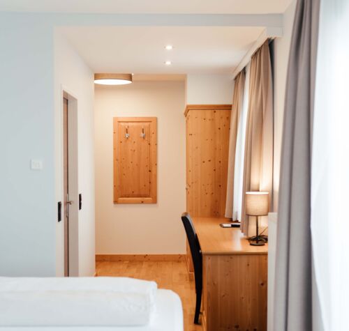 Schreibtisch und großer Holzschrank im Doppelzimmer des Landgasthofs Kirchbichl