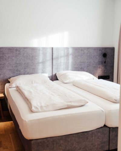 Das frisch bezogene Doppelbett im Doppelzimmer Gästhaus im 4-Sterne-Hotel Kirchbichl