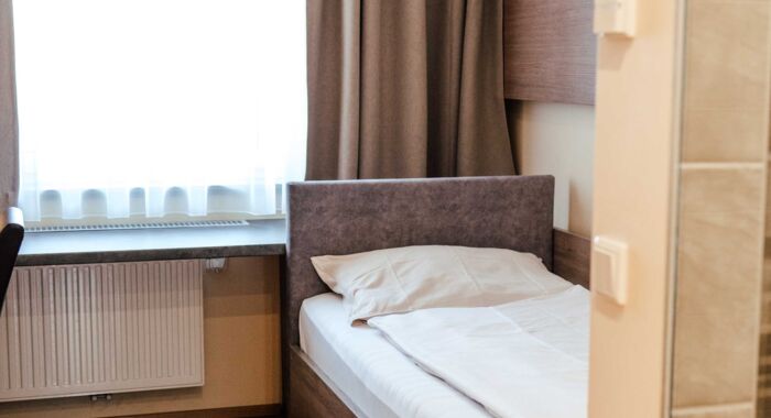 Einzelbett im Einzelzimmer mit großem Fenster im Hotel Kirchbichl