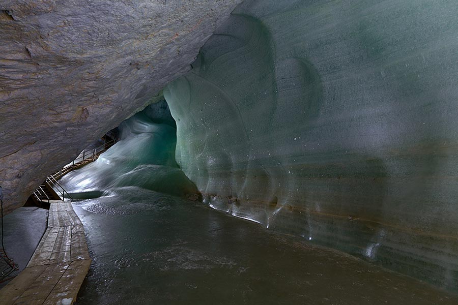 A narrow wooden walkway marks the path through the ice caves in Werfen.
